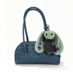 Blue handbag with a Bunnculus Plush Keychain, a green rabbit plush featuring purple hearts and star embroidery attached.
