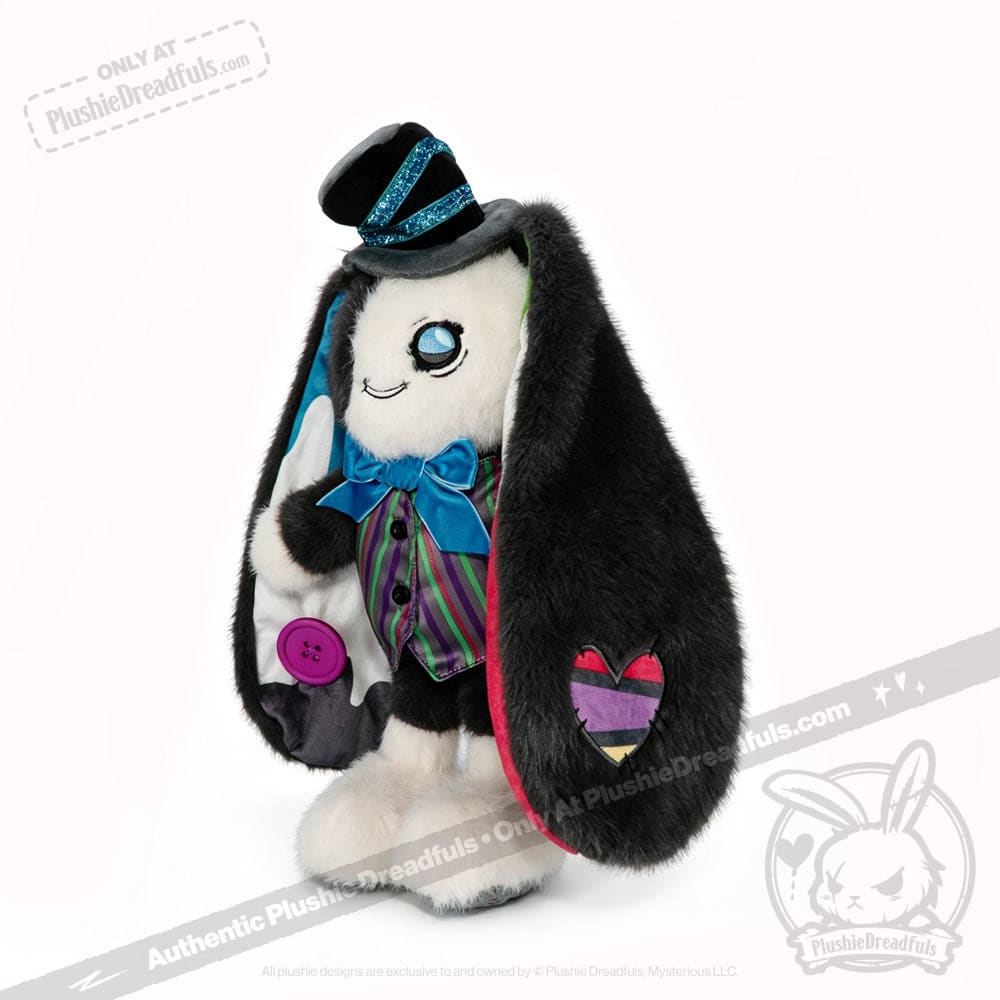 Plushie bunny with black ears, top hat, bow tie, and ADHD Mad Hatter flair; heart patch sports a rainbow-striped design.