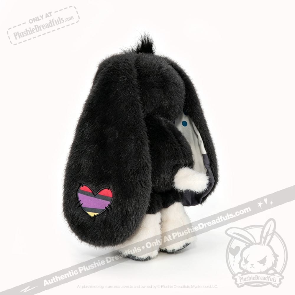 Plushie black bunny toy with long ears, blue polka dots, and a heart patch—perfect for acceptance and comfort.