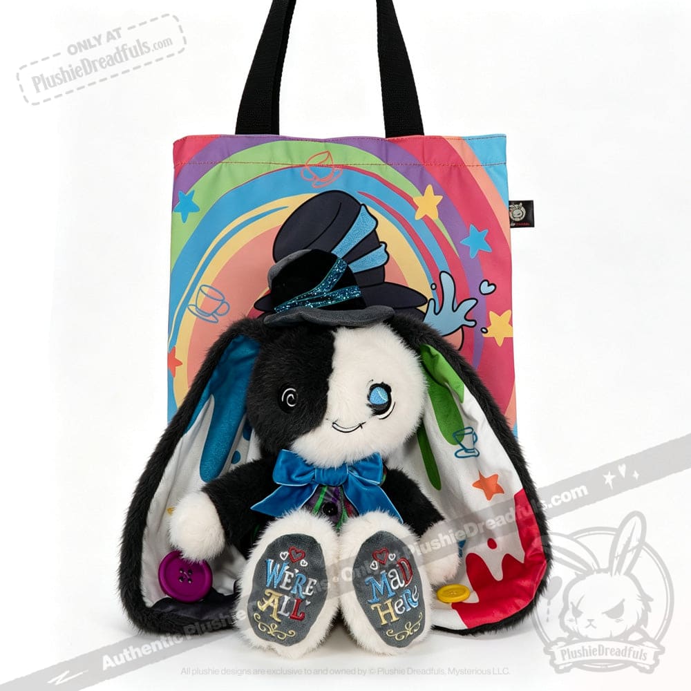 Plushie black-and-white bunny with a top hat sits before a rainbow tote, embracing ADHD Mad Hatter vibes and acceptance.