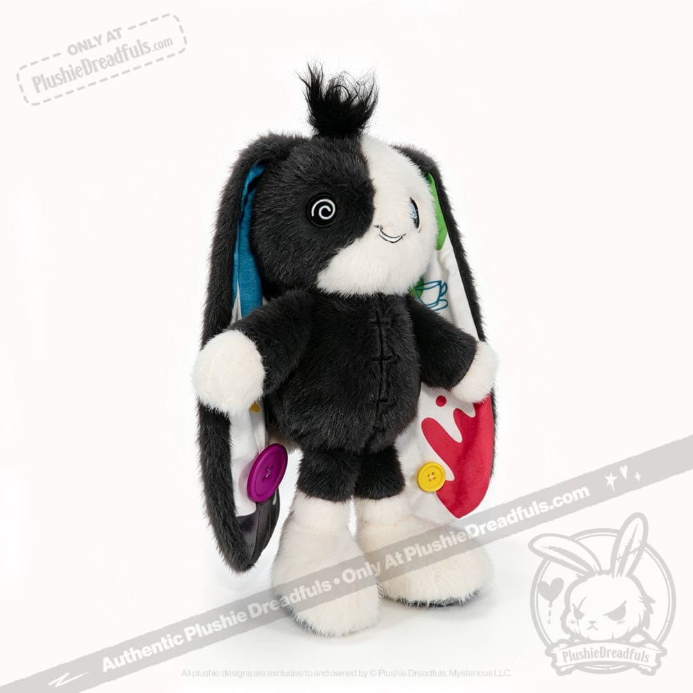 Plush bunny plushie with black and white fur, colorful buttons, and patterns inside its floppy ears—perfect for acceptance.